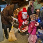 Der Weihnachtsmann verteilt einen Schokonikolaus an ein kleines Mädchen